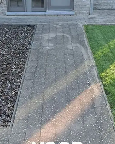 Donker betonpad langs een gazon