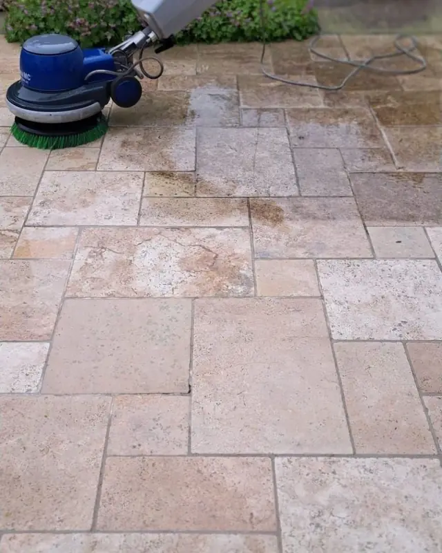 Borstelmachine op een terras in lichte natuursteen