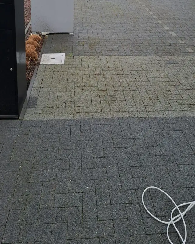 Parking in betonklinkers, onderaan gereinigd en bovenaan nog vuil