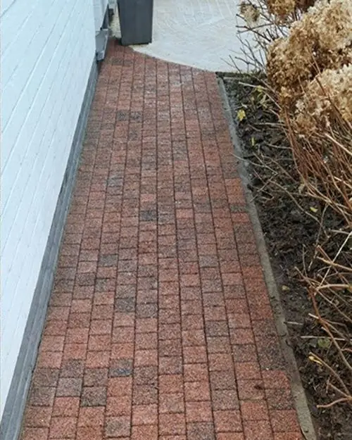 Rood klinkerpad langs de gevel na de reiniging