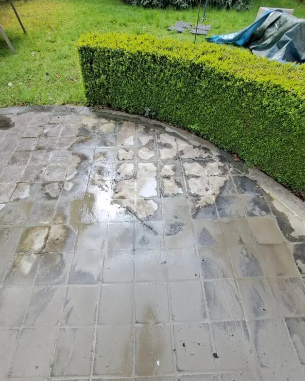 Rond terras in blauwe steen tijdens de reiniging