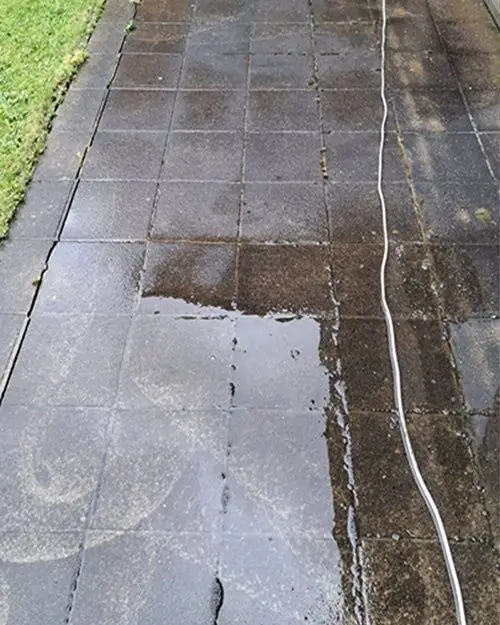 Terras in betontegels, half nat en vuil