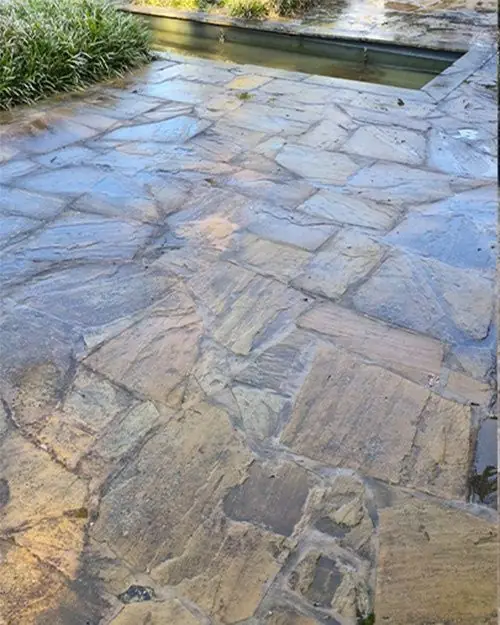 Natuurstenen terras in wildverband, donker en vuil